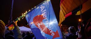 Eine Teilnehmerin schwingt eine AfD-Flagge während einer Kundgebung der islam- und ausländerfeindlichen Pegida-Bewegung 2020 in Cottbus.