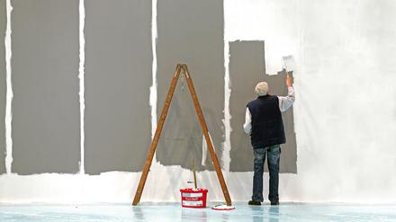 Ein älterer Herr mit grauen Haaren weißt eine Wand (Symbolbild).