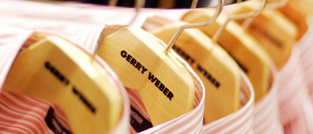 Herrenhemden des Modeherstellers Gerry Weber hängen in einem Ladenlokal auf Kleiderbügeln.