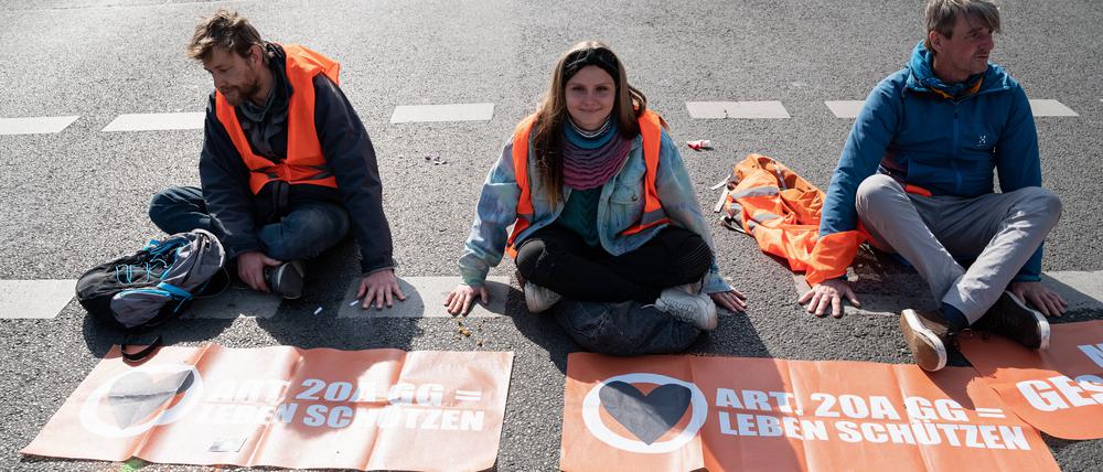 Klimademonstranten der so genannten Letzten Generation kleben auf der Fahrbahn einer Hauptstrasse am Ernst-Reuter-Platz in Berlin-Charlottenburg. 