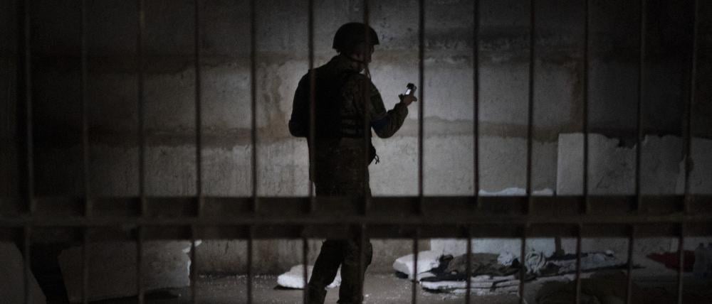 Ein ukrainischer Soldat steht in einem Keller, der nach Angaben der ukrainischen Behörden von Russland angeblich als Folterzelle benutzt worden sein soll.