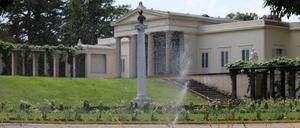 Warum werden Grünflächen (Park Sanssouci) in Potsdam tagsüber gewässert? In der Nachmittagshitze laufen die Wassersprinkler am Schloß Charlottenhof.