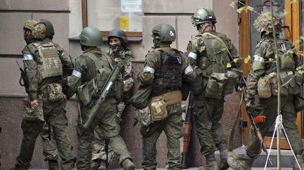 Russische Soldaten gehen eine Straße entlang. 