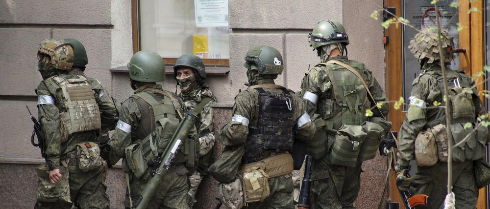 Russische Soldaten gehen eine Straße entlang.