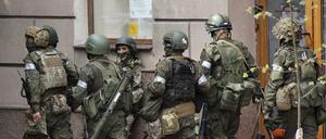 Russische Soldaten gehen eine Straße entlang. 