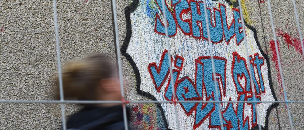 11.04.2019, Berlin: Ein Mädchen läuft an der Fichtenberg-Oberschule im Berliner Steglitz an Graffiti mit dem Schrift "Schule mit Vielfalt" vorbei. (zu dpa-Story "Hakenkreuz im Klassenzimmer: Wie Rechtsextremismus Schulen verunsichert" am 02.05.2019) Foto: Lisa Ducret/dpa +++ dpa-Bildfunk +++ | Verwendung weltweit