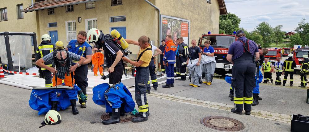 Einsatzkräfte im niederbayerischen Ortenburg tragen für den Einsatz Schutzanzüge. Nach einem Ammoniak-Austritt in einem Betrieb in Niederbayern mit mindestens acht Verletzten ist der Warnhinweis außerhalb des betroffenen Ortsteils von Ortenburg (Landkreis Passau) aufgehoben worden.