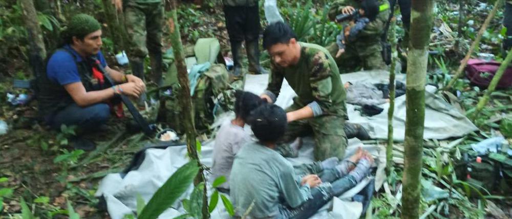 Auf diesem von der Pressestelle der kolumbianischen Streitkräfte veröffentlichten Foto kümmern sich Soldaten und indigene Männer um die vier Geschwister, die nach einem tödlichen Flugzeugabsturz vermisst wurden, im Dschungel von Solano im kolumbianischen Bundesstaat Caqueta.