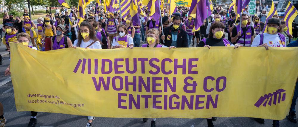 Bei einer Demonstration gegen hohe Mieten in Berlin halten Teilnehmer ein Transparent mit der Aufschrift „Deutsche Wohnen & Co enteignen“.