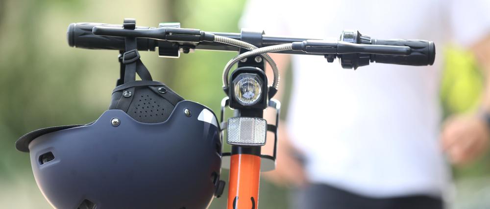 Ein Elektro-Tretroller von Circ steht samt Helm fahrbereit auf der Straße.
