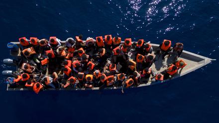 Migranten aus Eritrea, Libyen und dem Sudan sitzen in einem Holzboot, bevor sie von Helfern der spanischen Nichtregierungsorganisation Open Arms im Mittelmeer, etwa 30 Meilen nördlich von Libyen, unterstützt werden. 