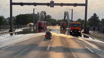 Hier der Blick von der gesperrten Fahrbahn - hinten links pumpt die Feuerwehr mit einem Schlauch das Wasser in die Havel.