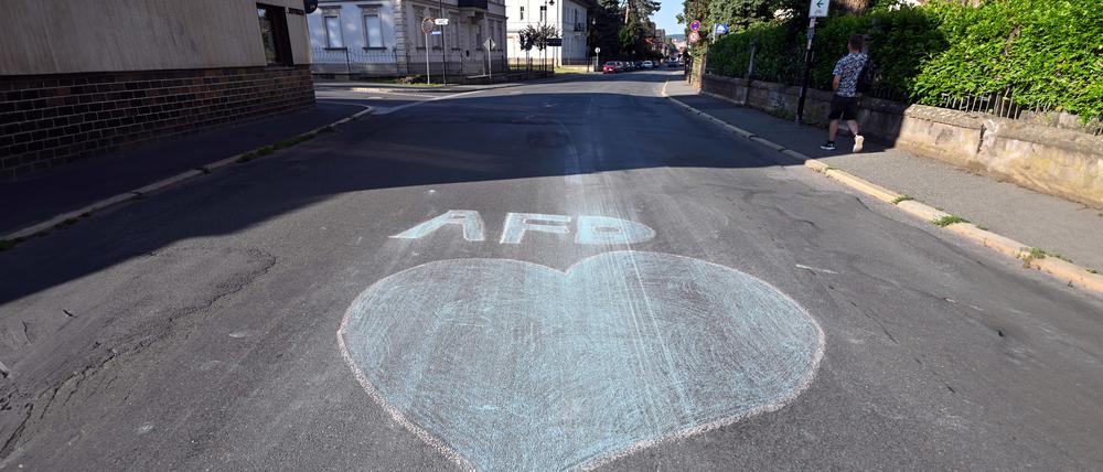Ein blaues Herz und der Schriftzug AfD sind mit Kreide auf eine Straße gemalt am Tag der Stichwahl des Landrats im Landkreis Sonneberg. 