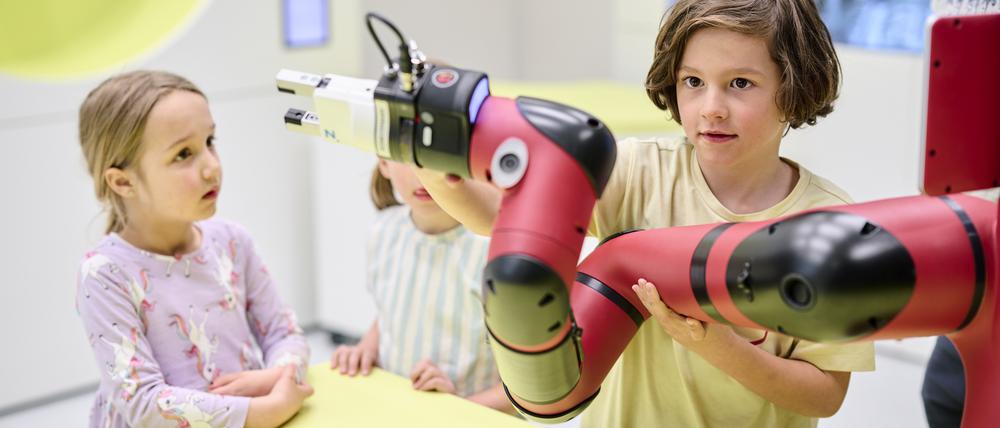 Kinder können im Foyer des Technikmuseums einen Roboterarm erkunden.