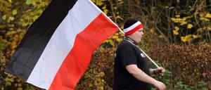 Ein Teilnehmer mit einer schwarz-weiß-roten Reichsflagge während einer Demonstration von Reichsbürgern und anderen Rechtsextremen in Potsdam im Jahr 2020. 
