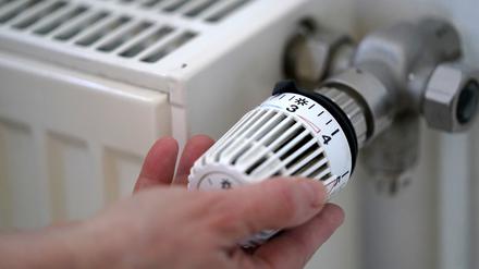 Eine Frau dreht an einem Heizungsthermostat. Das neue Heizungsgesetz ist noch nicht beschlossen. 