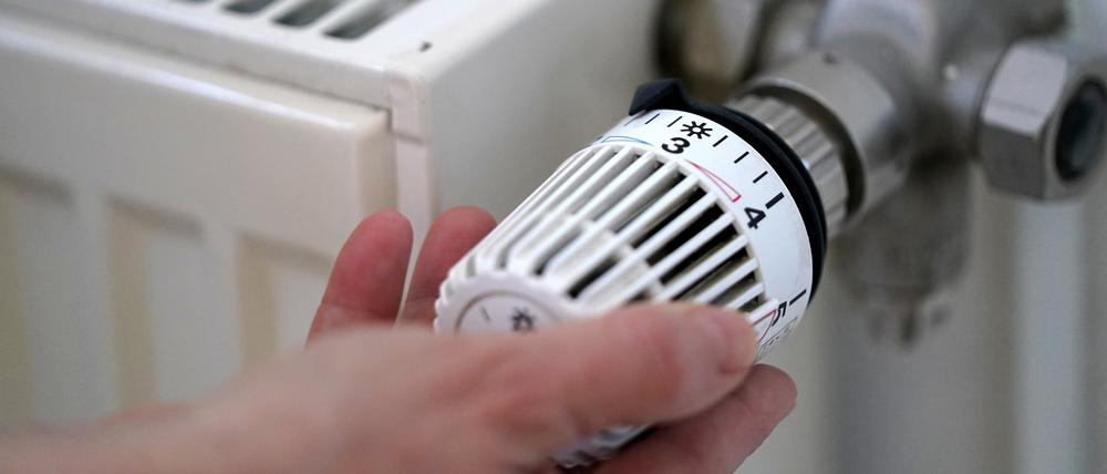 Eine Frau dreht an einem Heizungsthermostat. Das neue Heizungsgesetz ist noch nicht beschlossen. 