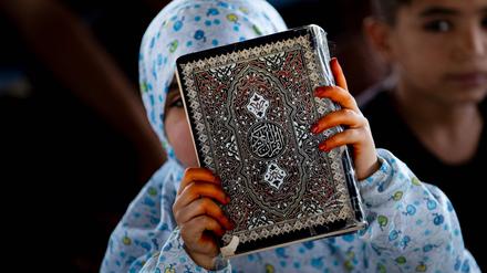 Eine Frau hält den Koran in den Händen.