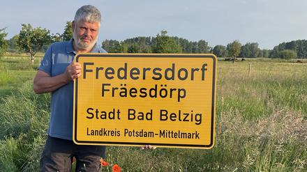 Bodo Sternberg, Ortsvorsteher von Fredersdorf hält das neue Ortsschild in den Händen.