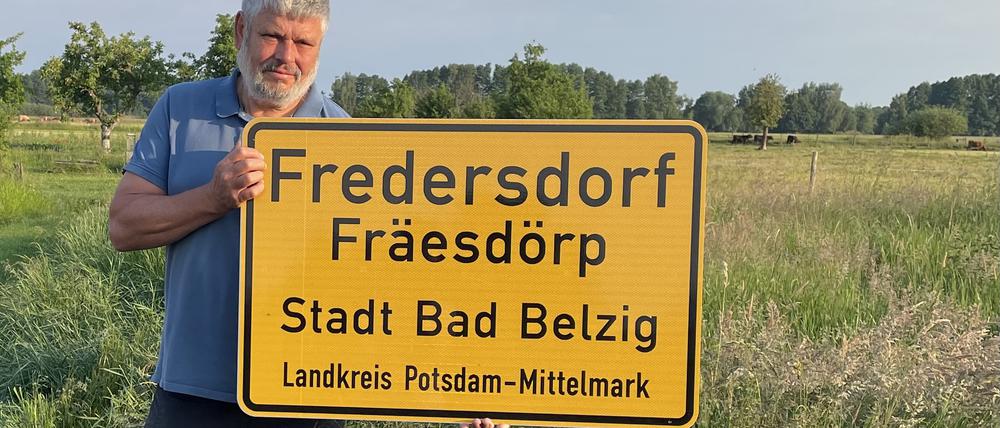 Bodo Sternberg, Ortsvorsteher von Fredersdorf hält das neue Ortsschild in den Händen.