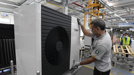 Ein Mitarbeiter der Firma Vaillant montiert eine Wärmepumpe im Stammwerk des Unternehmens.