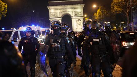 Polizisten patrouillieren vor dem Arc de Triomphe auf der Champs Elysees in Paris. 