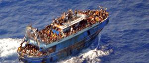 Ein undatiertes Handout-Foto der griechischen Küstenwache zeigt Migranten an Bord eines Bootes während einer Rettungsaktion, bevor ihr Boot auf dem offenen Meer vor Griechenland kentert.