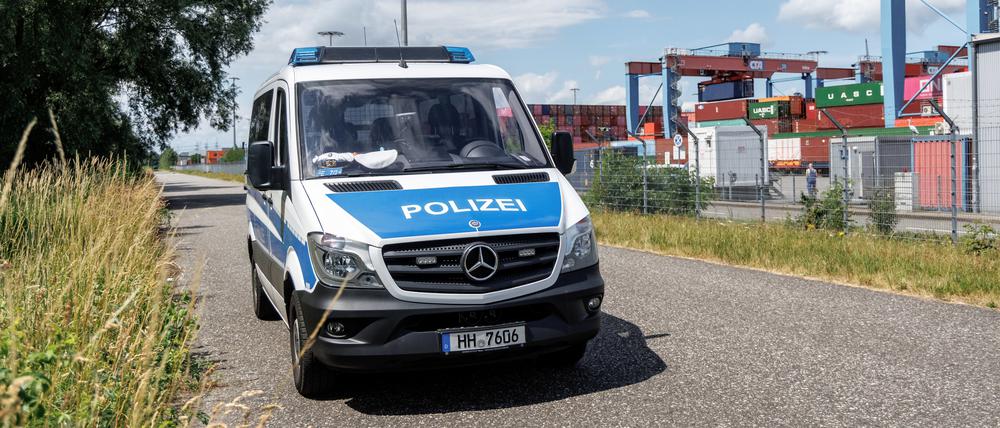 Ein Polizeifahrzeug park am Außenzaun des Containerterminals Hamburg-Altenwerder. 