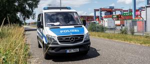 Ein Polizeifahrzeug park am Außenzaun des Containerterminals Hamburg-Altenwerder.