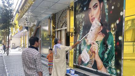  Ein Mitarbeiter eines Schönheitssalons übermalt ein großes Foto einer Frau an der Wand, nachdem die Taliban in die afghanische Hauptstadt Kabul eingedrungen sind. (Archivbild)