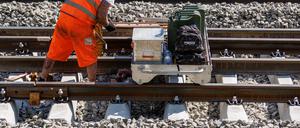 Ein Arbeiter verlascht auf einer Baustelle der Bahnstrecke Würzburg - Nürnberg neu gelegte Schienenstücke (Symbolbild).