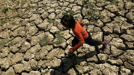 Ein philippinisches Kind läuft in der Provinz Cavite auf den Philippinen in einem ausgetrockneten Bewässerungskanal spazieren, der durch das Wetterphänomen „El Nino“ ausgetrocknet war. (Archivbild)