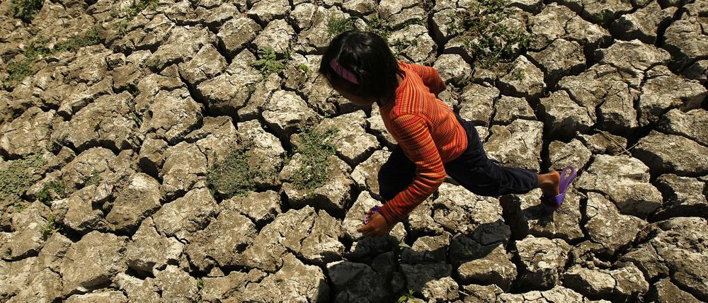 Ein philippinisches Kind läuft in der Provinz Cavite auf den Philippinen in einem ausgetrockneten Bewässerungskanal spazieren, der durch das Wetterphänomen „El Nino“ ausgetrocknet war. (Archivbild)