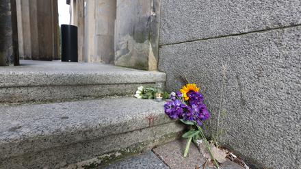 Blumen und eine Kerze liegen vor dem Eingang zum Rosa-Luxemburg-Gymnasium im Bezirk Berlin-Pankow.