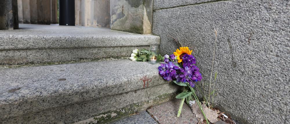 Blumen und eine Kerze liegen vor dem Eingang zum Rosa-Luxemburg-Gymnasium im Bezirk Berlin-Pankow.