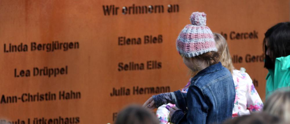 Schüler legen bei einer Gedenkfeier Rosen vor eine Gedenktafel mit den Namen der verstorbenen Opfer das Absturzes der Germanwings-Maschine (Archivbild).