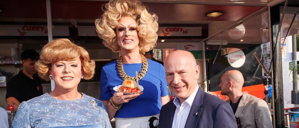 Kai Wegner (CDU), Regierender Bürgermeister Berlin, steht mit Margot Schlönzke (l) und Jurassica Parka beim Berliner Hoffest vor dem Roten Rathaus beim Curry36.