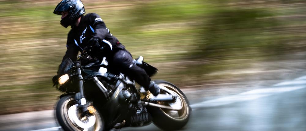Ein Motorradfahrer fährt auf einer Landstraße.