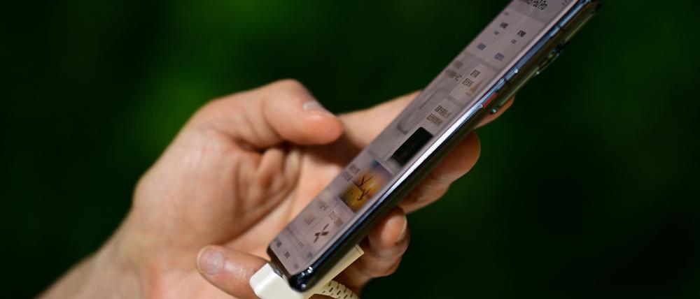 A man tests a Huawei smartphone at the Mobile World Congress (MWC) in Shanghai on June 28, 2023. (Photo by Pedro PARDO / AFP)