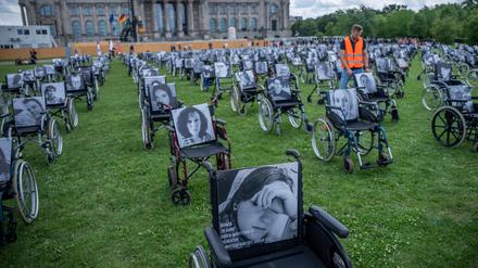 Rollstühle mit Bildern und Namen von Long Covid, ME/CFS und Post Vac Betroffenen erinnern vor dem Bundestag an die Schicksale von Langzeiterkrankten.
