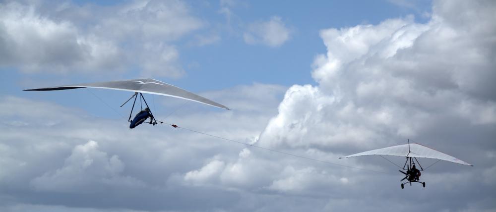 Über den Wolken. Im Flachland wird der Drache (links) von einem Flugzeug (rechts) in die Luft gezogen, um die nötige Höhe zu erreichen.