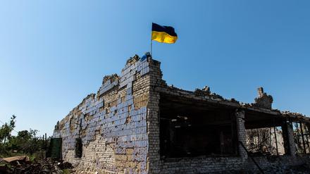 Eine ukrainische Flagge weht auf einem zerstörten Gebäude in Donezk.