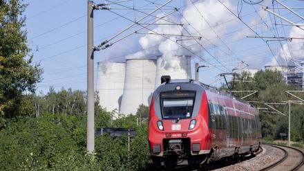 Ein Regionalzug fährt vor den Kühltürmen des Kraftwerks Jänschwalde vorbei. Die Deutschen Bahn hat heute ihre Entwicklungspläne für die Region Lausitz und den Standort Cottbus im Werk der DB Fahrzeuginstandhaltung Cottbus im Beisein von Bundesfinanzminister Scholz, Bundesverkehrsminister Scheuer und der Ministerpräsidenten Woidke (Brandenburg) und Kretschmer (Sachsen) vorgestellt. Die Erweiterung des Bahnwerks zählt zu den Investitionen des Bundes im Rahmen der Strukturstärkung der Lausitz, weil der Ausstieg aus der Braunkohle bis 2038 geplant ist. +++ dpa-Bildfunk +++
