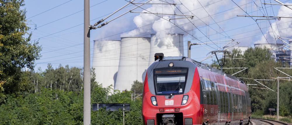 Ein Regionalzug fährt vor den Kühltürmen des Kraftwerks Jänschwalde vorbei. Die Deutschen Bahn hat heute ihre Entwicklungspläne für die Region Lausitz und den Standort Cottbus im Werk der DB Fahrzeuginstandhaltung Cottbus im Beisein von Bundesfinanzminister Scholz, Bundesverkehrsminister Scheuer und der Ministerpräsidenten Woidke (Brandenburg) und Kretschmer (Sachsen) vorgestellt. Die Erweiterung des Bahnwerks zählt zu den Investitionen des Bundes im Rahmen der Strukturstärkung der Lausitz, weil der Ausstieg aus der Braunkohle bis 2038 geplant ist. +++ dpa-Bildfunk +++