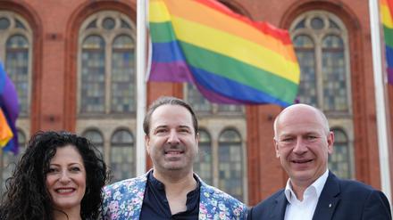 Kai Wegner (r, CDU), Regierender Bürgermeister von Berlin, Alexander Scheid (M), Landesgeschäftsführer des Lesben- und Schwulenverbandes (LSVD), und Cansel Kiziltepe (SPD), Senatorin für Arbeit, Soziales, Gleichstellung, Integration, Vielfalt und Antidiskriminierung des Landes Berlin, haben gemeinsam die Regenbogenflagge vor dem Roten Rathaus gehisst. 