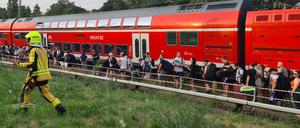 Fahrgäste stehen in der Nähe des S-Bahnhofs Birkenwerder (Landkreis Oberhavel) neben dem Zug.