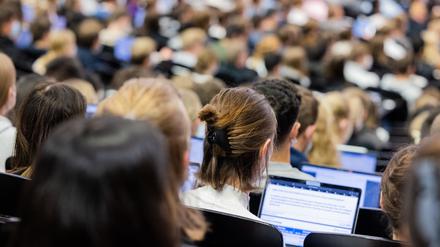 Studentinnen und Studenten sitzen während einer Vorlesung in einem Hörsaal. 