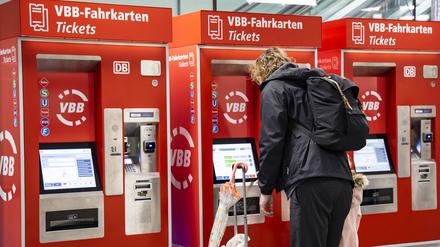 Menschen kaufen Fahrkarten an den Automaten im DB Reisezentrum in Fredrichstrasse in Berlin.