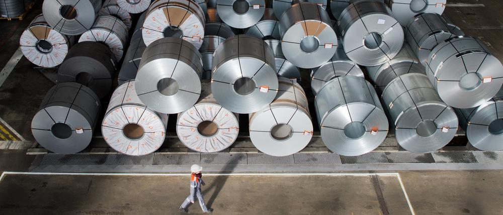 Eine Mitarbeiterin geht auf dem Gelände der Salzgitter AG vor sogenannten Coils (aufgewickelte Metallbänder) vorbei (Archiv).