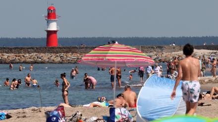 Badegäste genießen die Sonne am Ostseestrand. Am Wochenende meldet sich der Hochsommer mit entsprechenden Temperaturen zurück. 